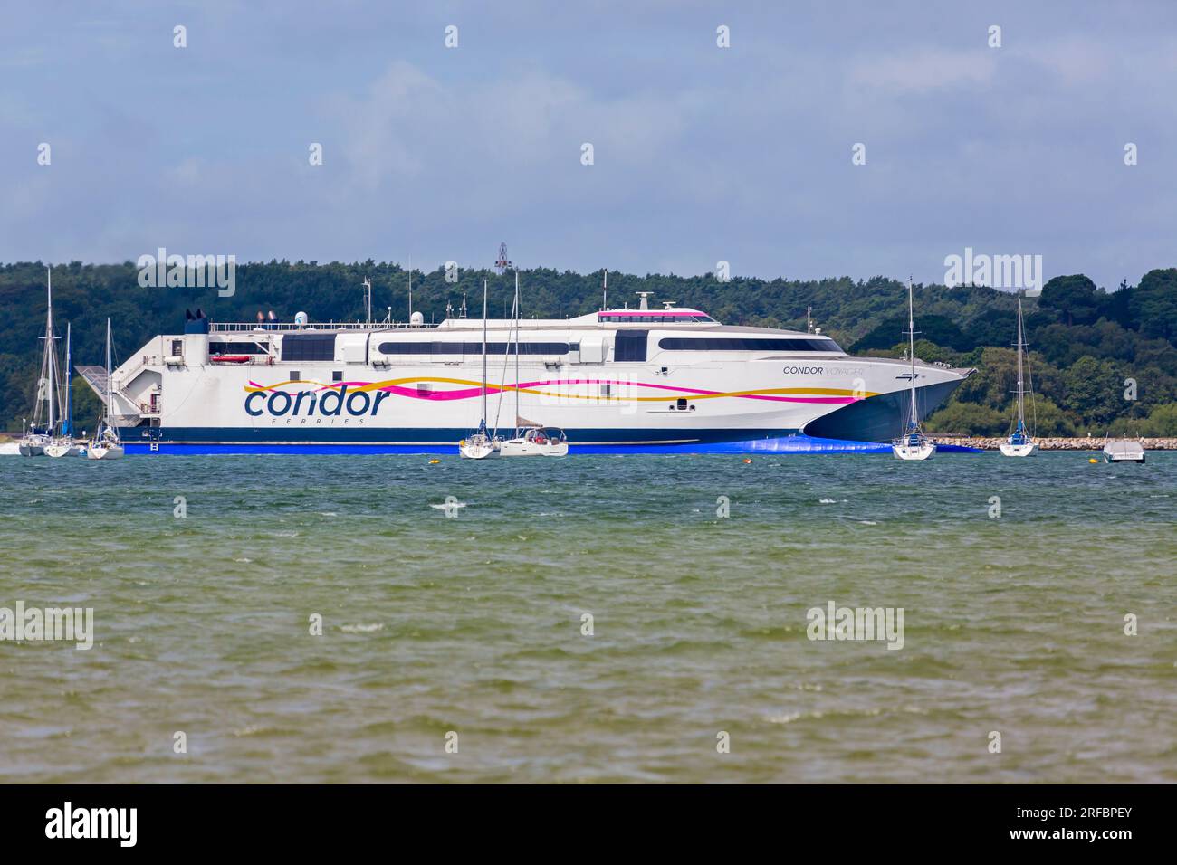 Condor Ferries traghetto Condor Voyager che viaggia attraverso gli yacht attraverso Poole Harbour Dorset Regno Unito, da St Malo, Francia via Jersey nelle Isole del Canale a luglio Foto Stock