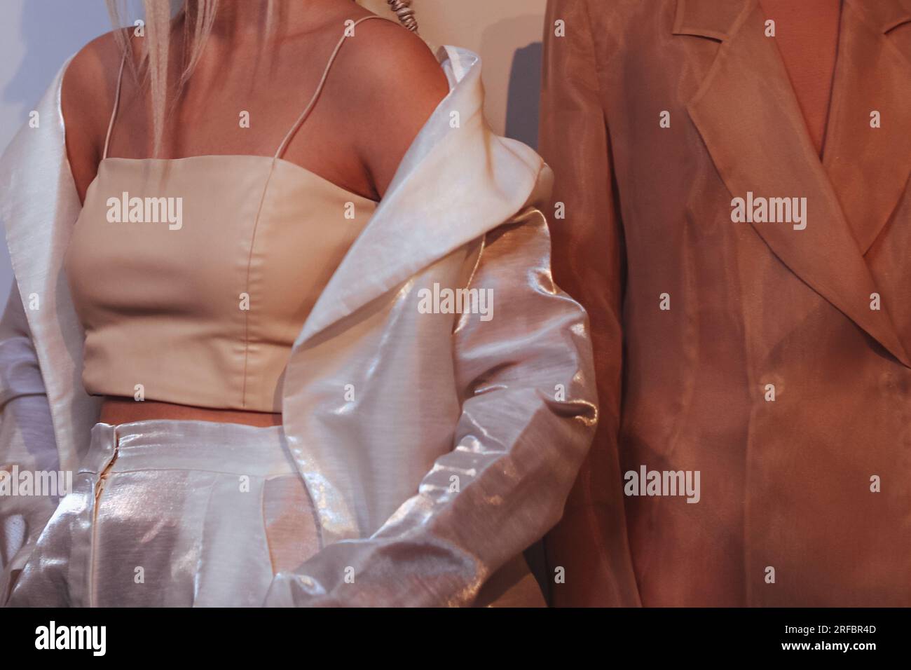 Figure ritagliate di due modelle di moda donne che indossano abiti bianchi beige marrone alla moda. Outfit alla moda, concetto di abbigliamento femminile. Foto Stock