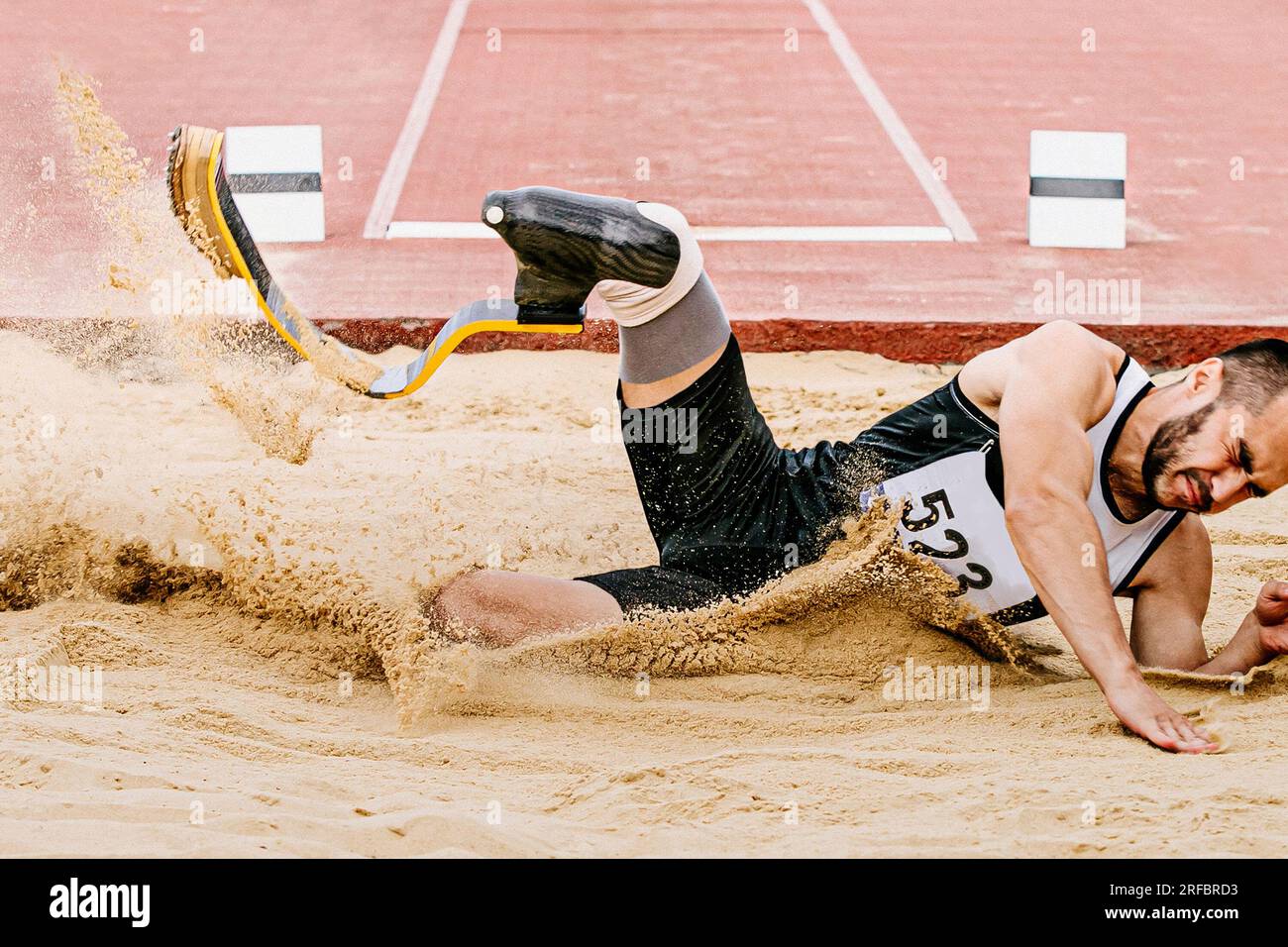 para atleta salto lungo, atterraggio sabbia in gare di atletica, giochi sportivi estivi Foto Stock