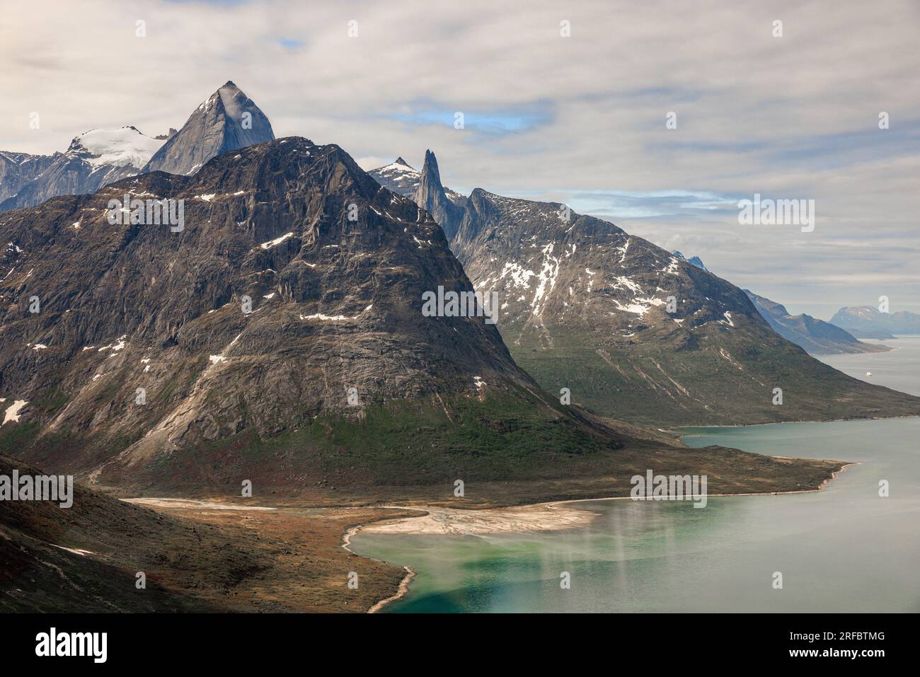 foto aerea di magnifiche montagne rocciose con lati ripidi che scendono giù nell'acqua verde blu del fiordo di tasermiut in groenlandia Foto Stock