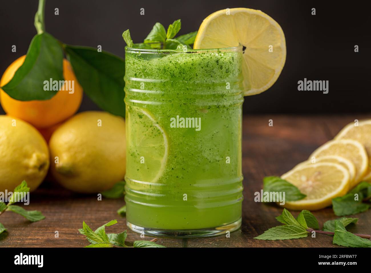 Limonata con ghiaccio e menta in vetro su tavolo di legno Foto Stock