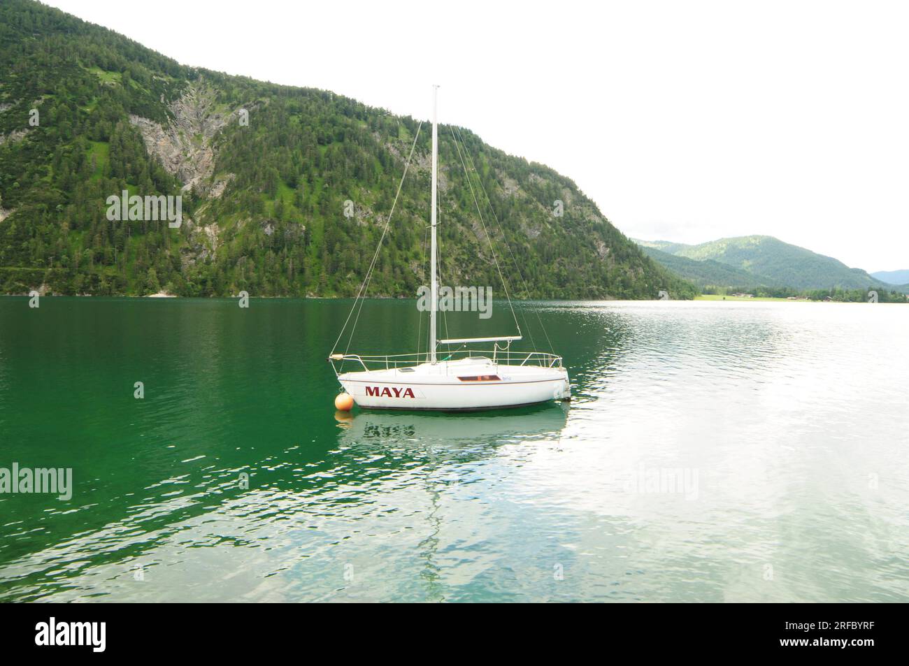 Barca sul lago Achensee in Austria, il lago riflette la montagna verde e prende il colore verde. Foto Stock