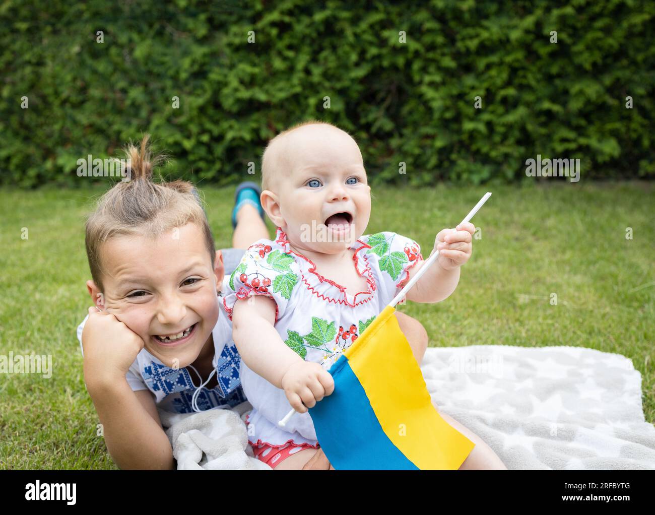 Ritratto di due felici ragazzi e ragazze ucraini di diverse età in abiti nazionali, camicie ricamate. educazione al patriottismo. Giorno dell'indipendenza. C Foto Stock