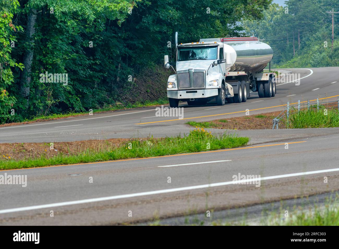 Shot orizzontale di un veicolo per la consegna di benzina su una strada secondaria rurale. Foto Stock