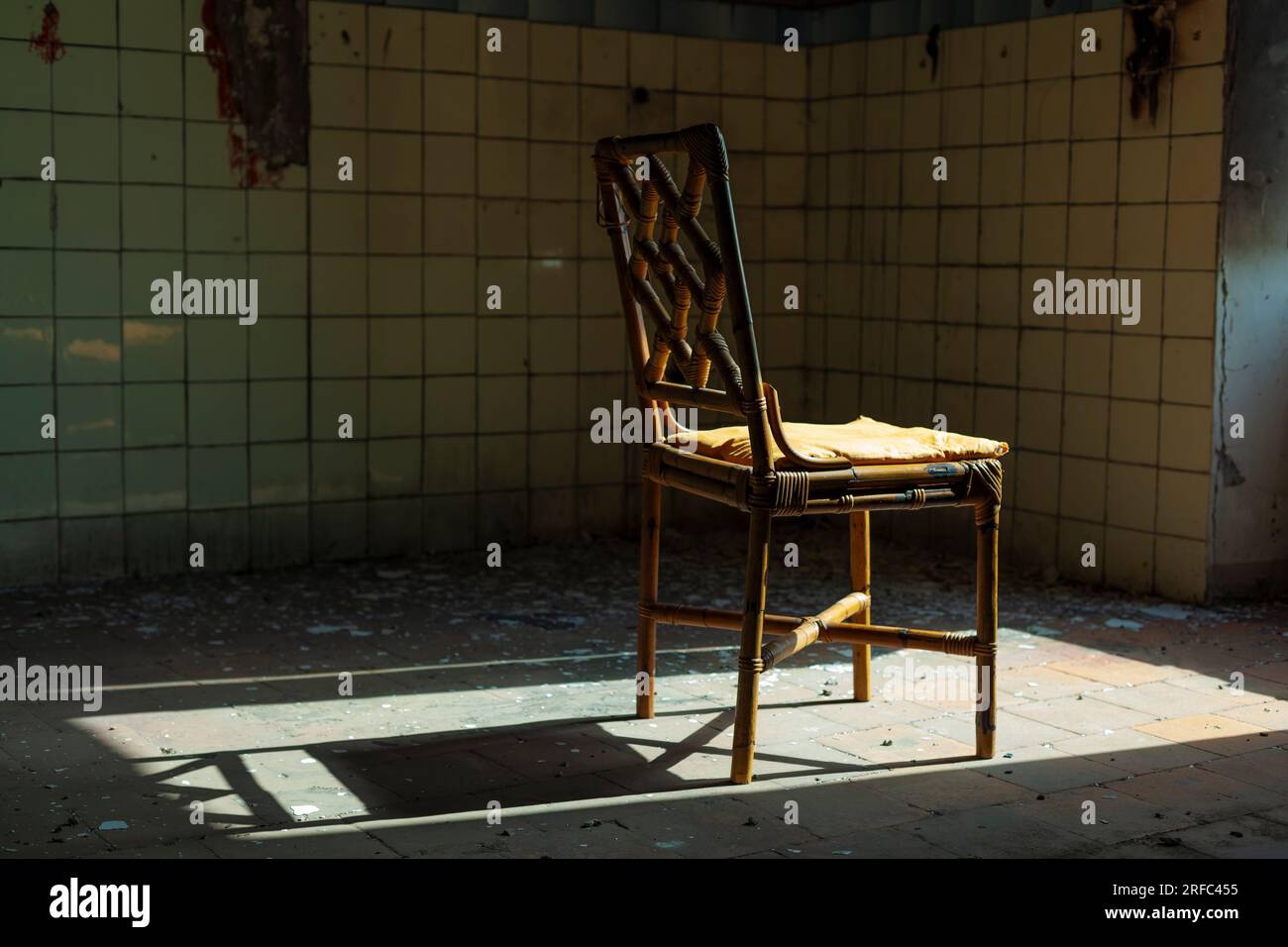 Immagine inquietante di uno spazio abbandonato - una sedia vecchia in un ambiente degradato Foto Stock
