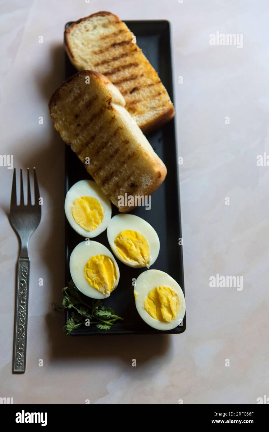 Ingredienti per la colazione, pane e uova su un vassoio nero Foto Stock