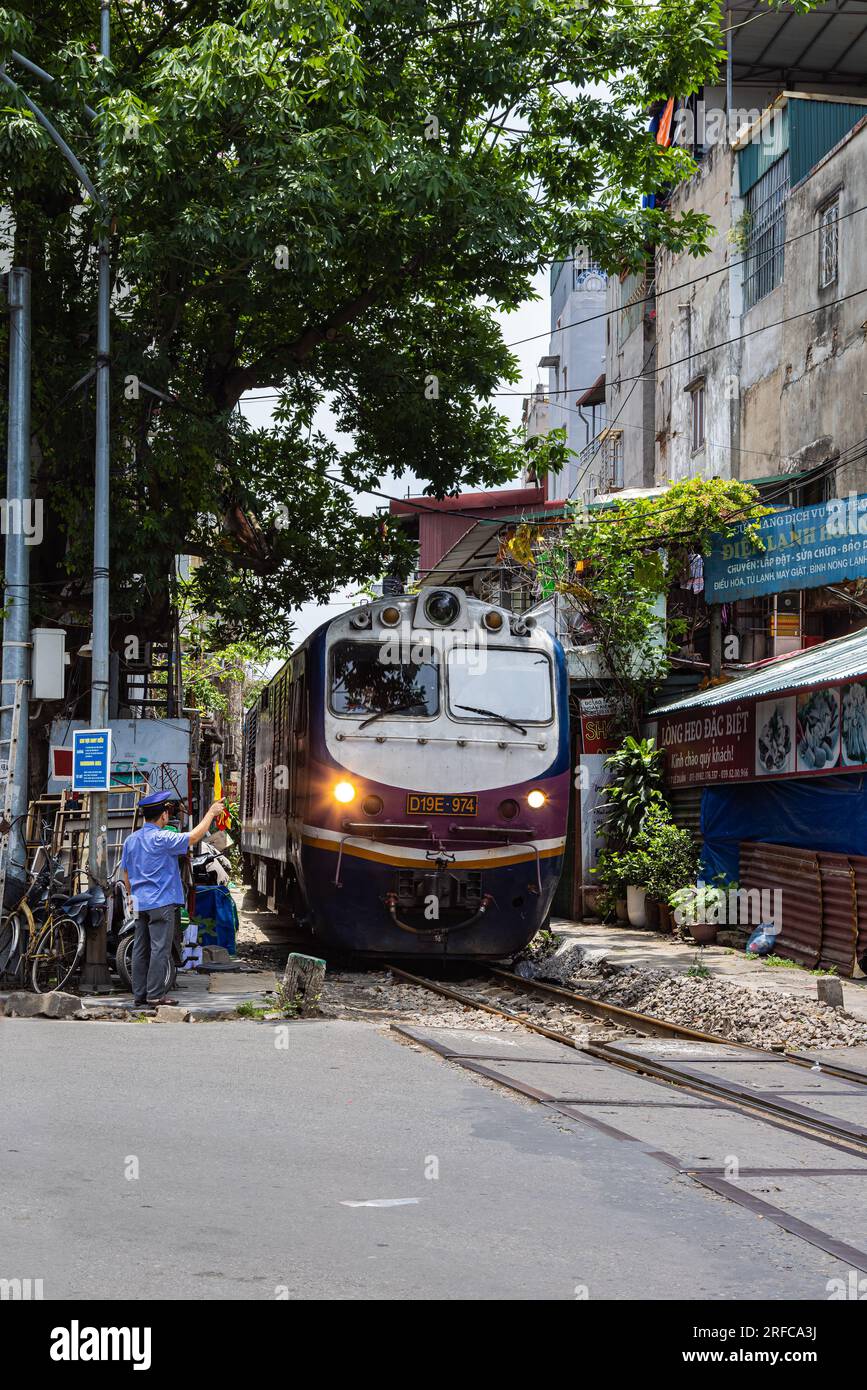 Hanoi, Vietnam - 28 maggio 2023: Train Street ad Hanoi è una stradina stretta e trafficata con binari. Case a maglia vicine, adornate di piante, distano pochi centimetri da qui Foto Stock