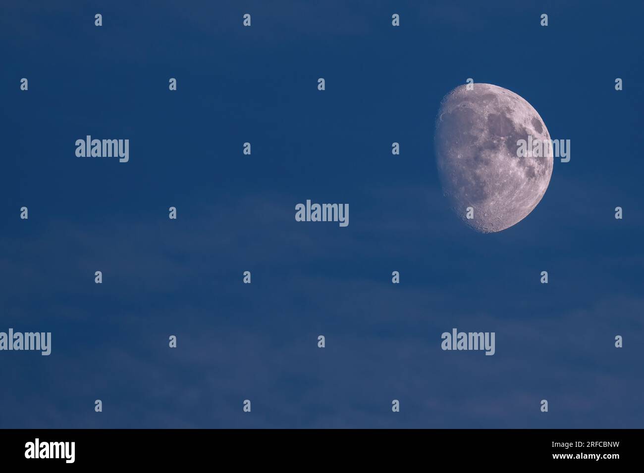 bella mezzaluna nel cielo notturno limpido con sagome di alberi sulle montagne Foto Stock