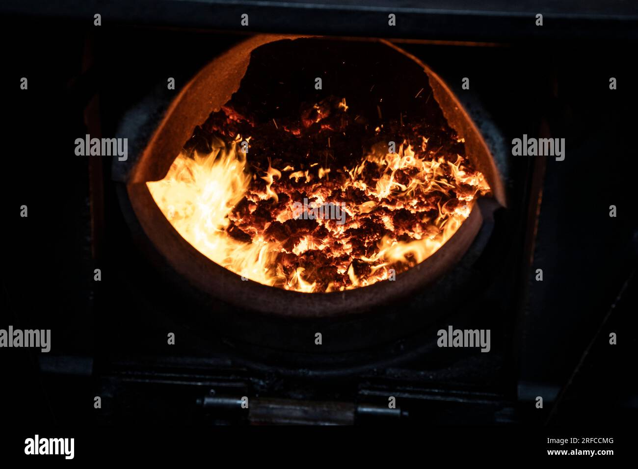 Una vista ravvicinata di una cassetta dei vigili del fuoco del treno a vapore dove il carburante viene bruciato sulle griglie per produrre calore per bollire l'acqua nella caldaia della locomotiva Foto Stock