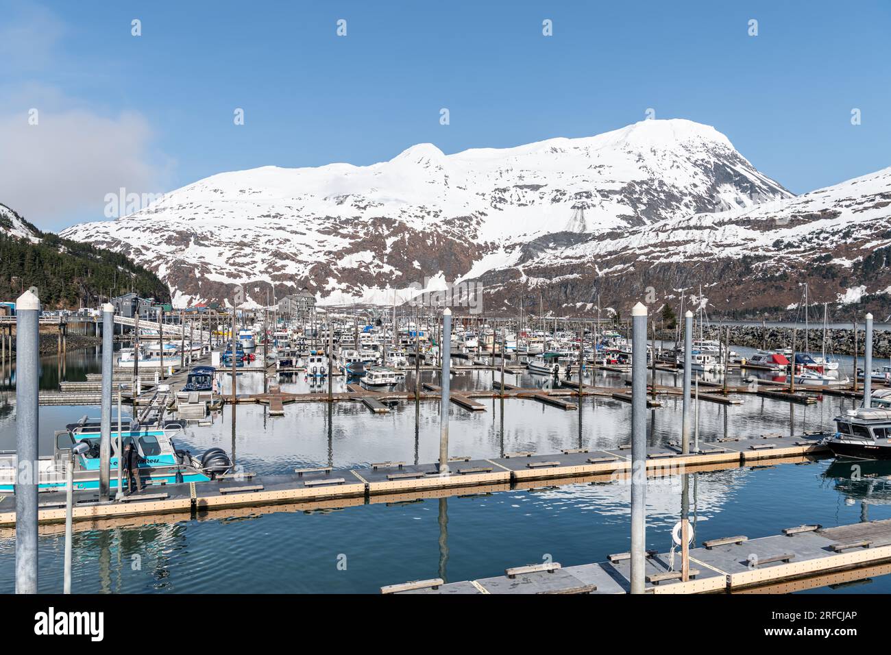 Montagna innevata che si riflette nelle calme acque del porto turistico di Whittier, Whittier, Alaska, USA Foto Stock