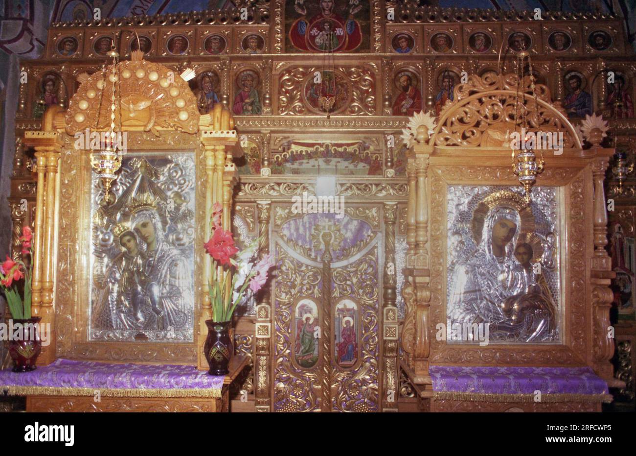 Contea di Iasi, Romania, 1999. Interno della chiesa del XVII secolo nel monastero di Hadambu. Iconostasi e icone raffiguranti la Vergine Maria che tiene il bambino. Foto Stock