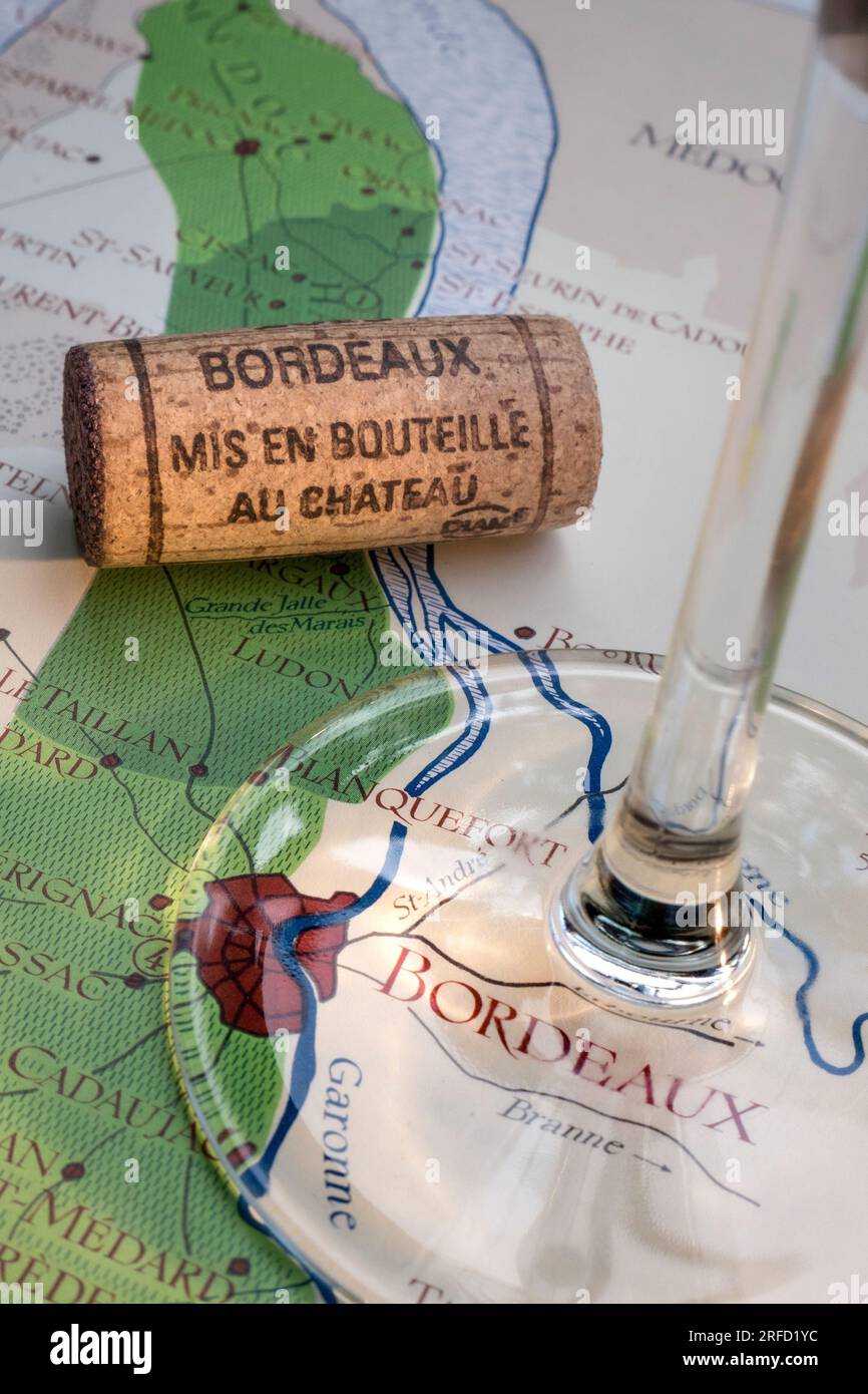Mappa del tour in sughero con degustazione di vini francesi di Bordeaux, con bicchiere di vino, tappo in primo piano, sulla vecchia mappa storica delle aree vinicole di Bordeaux con bicchiere di vino. Foto Stock