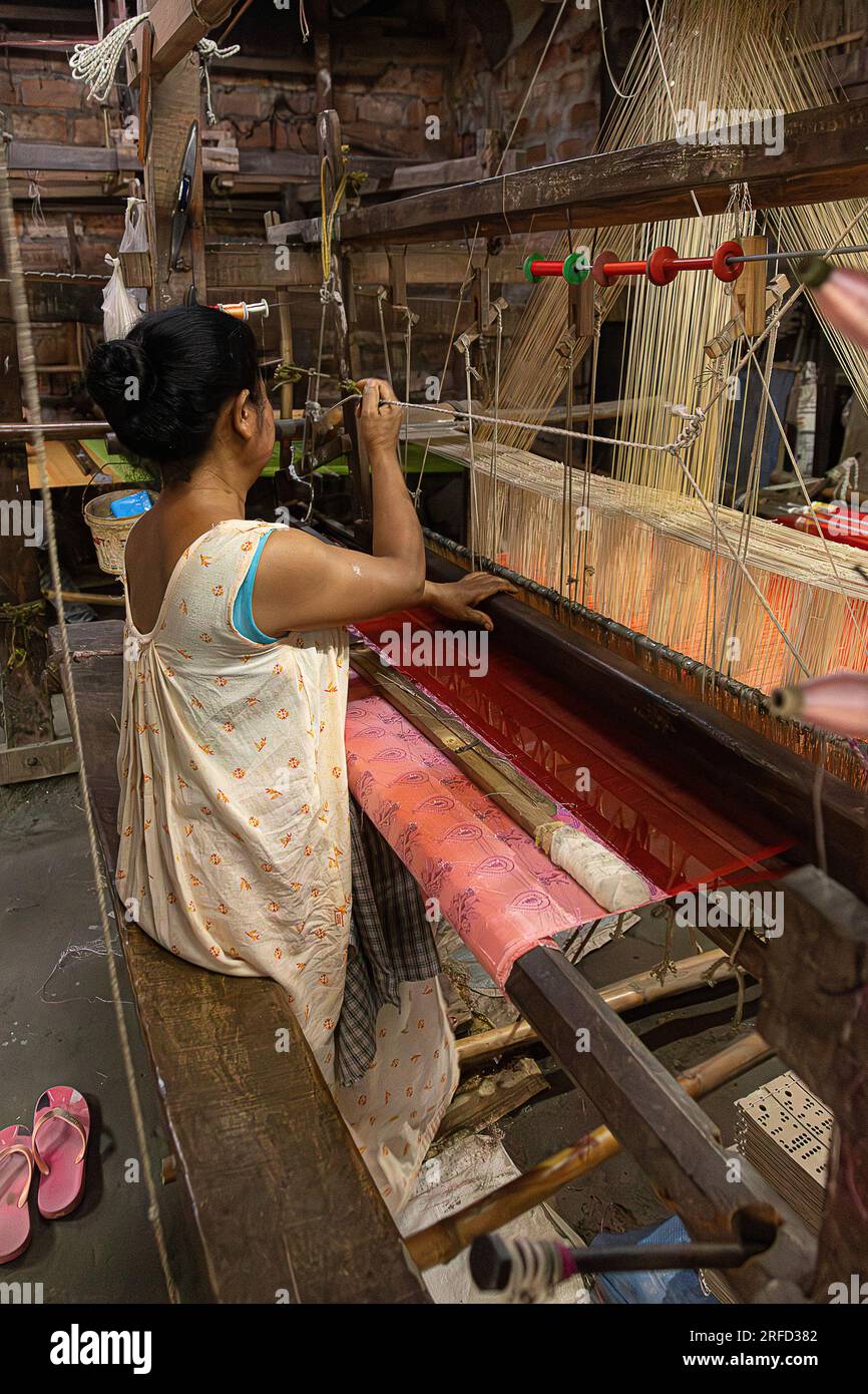 donna; tessitrice di seta; tessitura di seta; produzione di seta; fabbricazione di seta; Industria; Sualkuchi; Assam; cultura assamese; artigianato tradizionale; Telaio; India; Ind Foto Stock