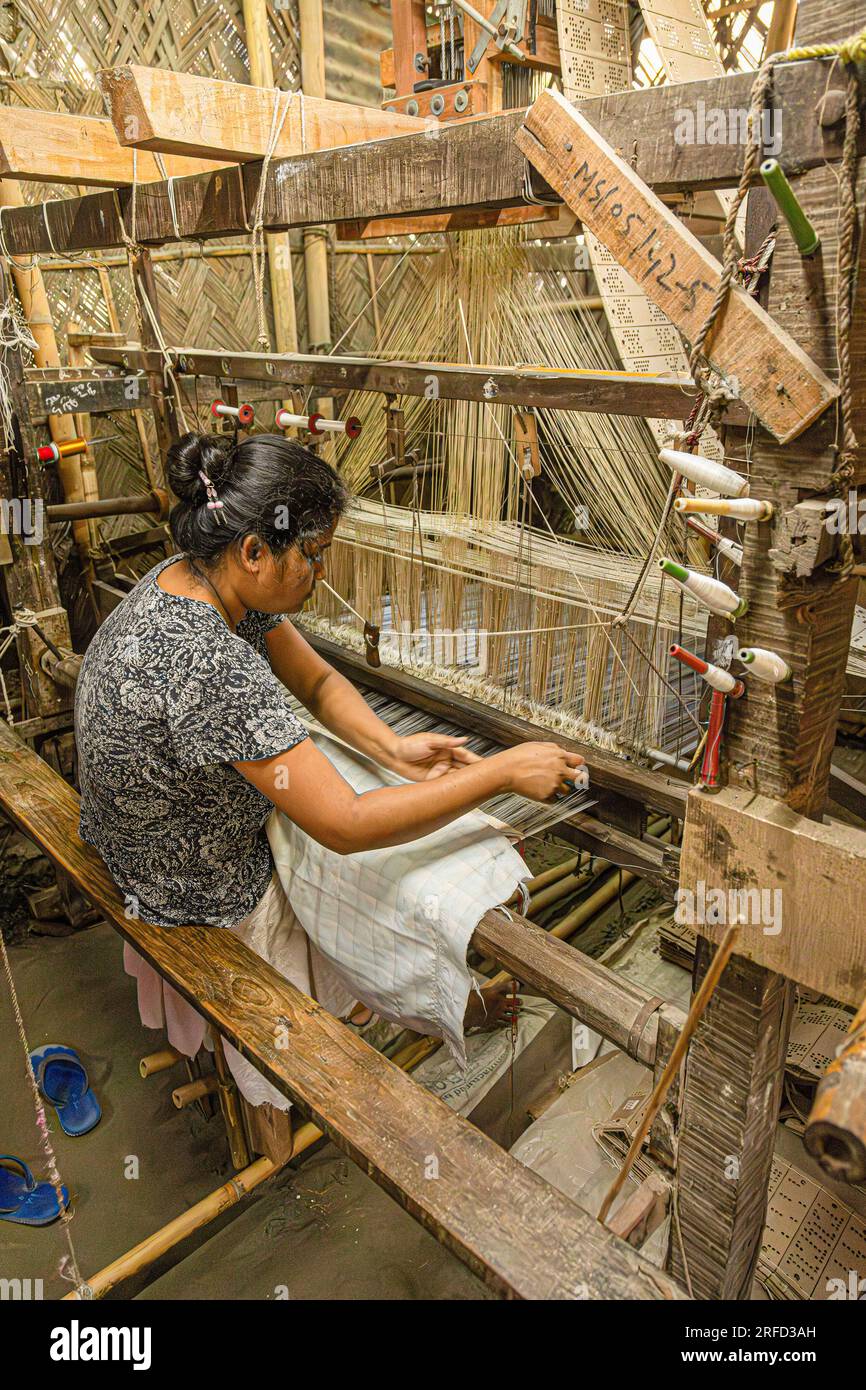 Donna che tessono seta su un telaio a Sualkuchi, una piccola città dell'Assam, che è il centro dell'industria della tessitura della seta. Foto Stock