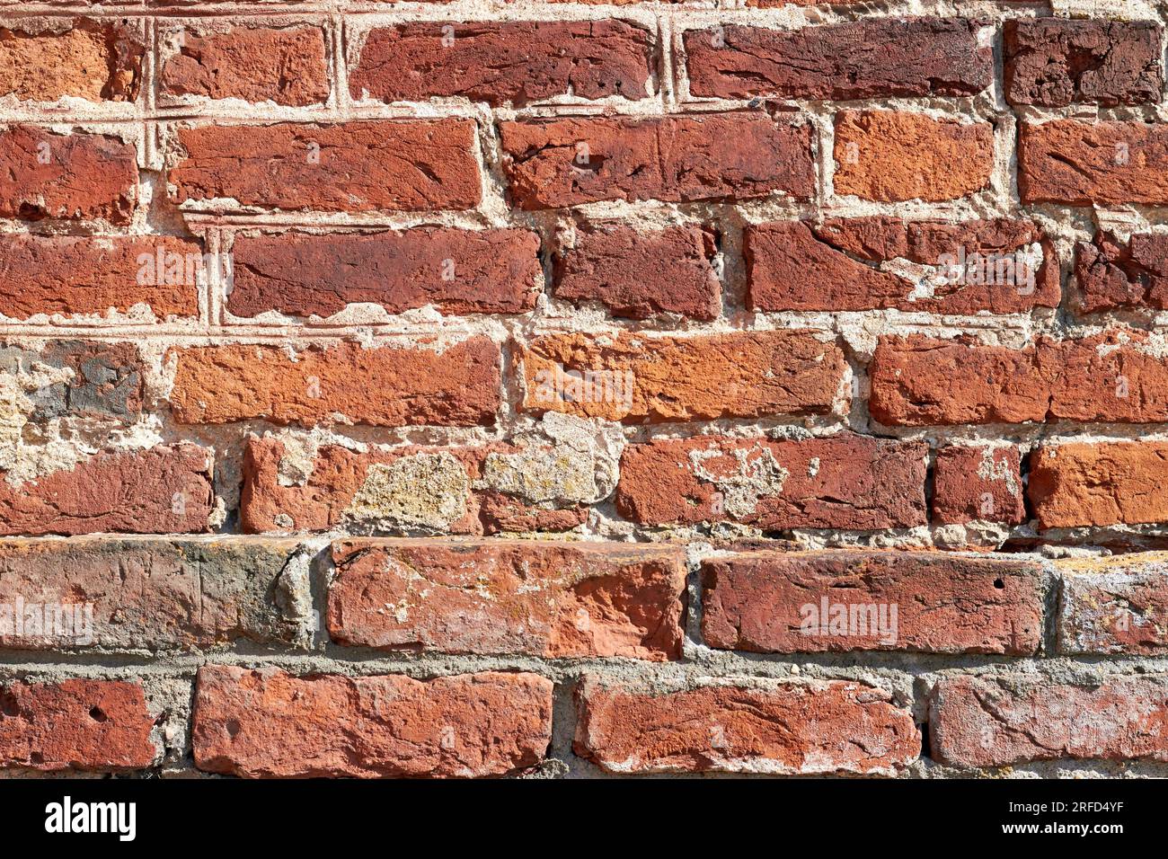 Antica parete scheggiata in mattoni di argilla rossa. Sfondo testurizzato di alta qualità per il design Foto Stock
