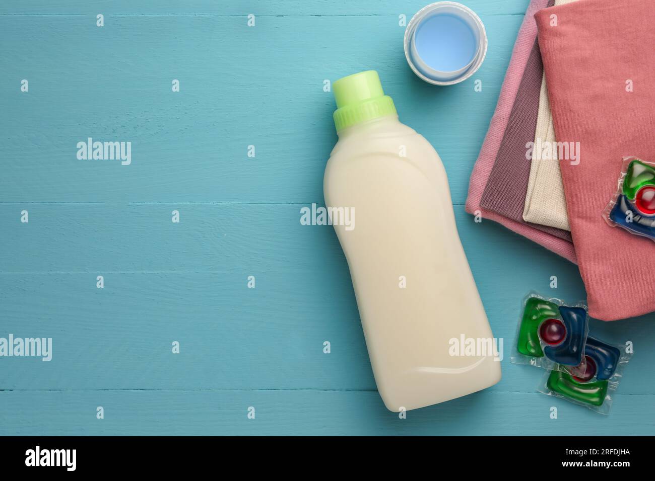 Composizione piatta con flacone di addolcitore in tessuto su tavolo in legno azzurro. Spazio per il testo Foto Stock