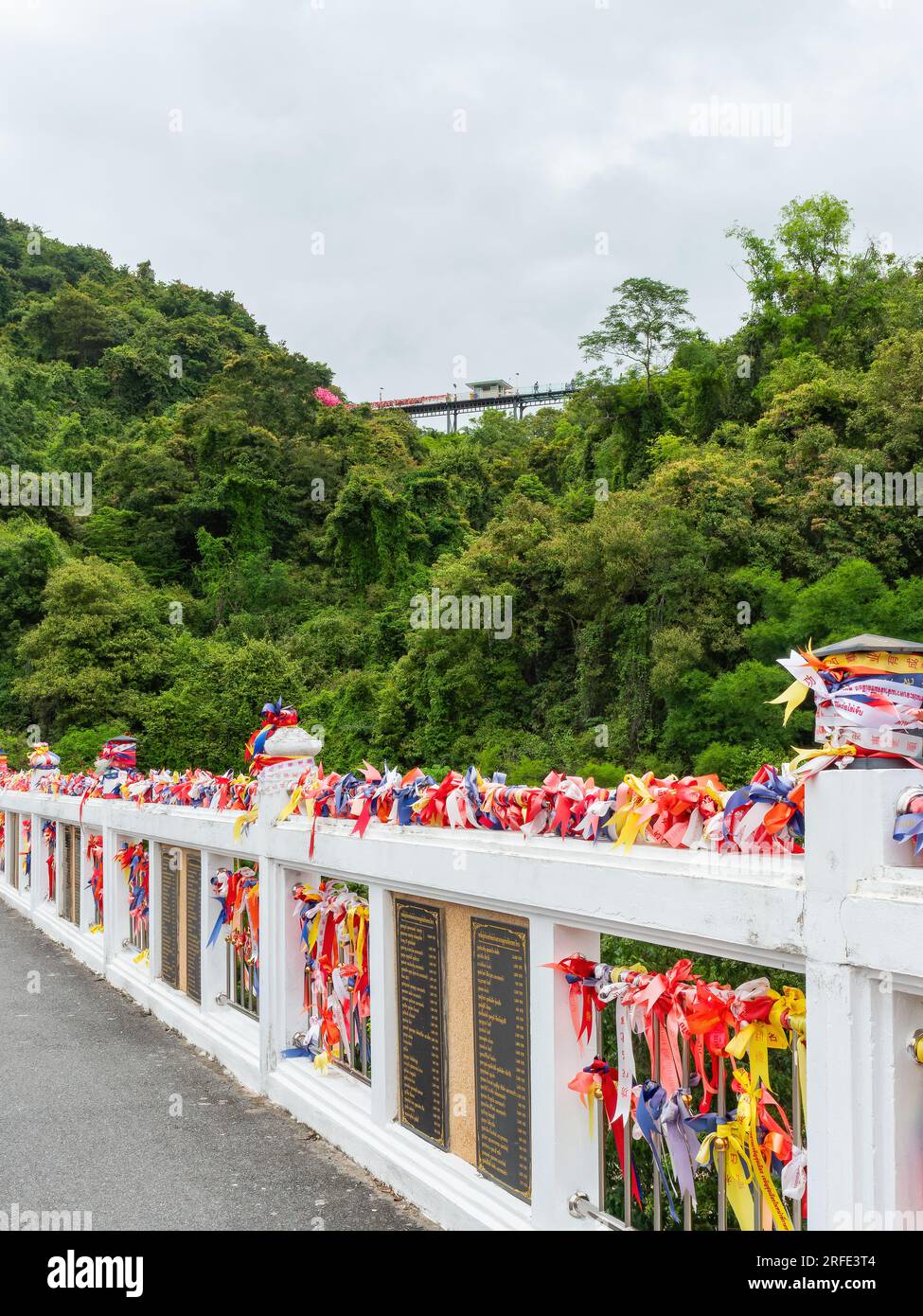 Wat Khao Tabaek a Chonburi, Thailandia. C'è un ponte con pavimento in vetro tra due colline. Il ponte da ascendere è decorato con nastri colorati Foto Stock