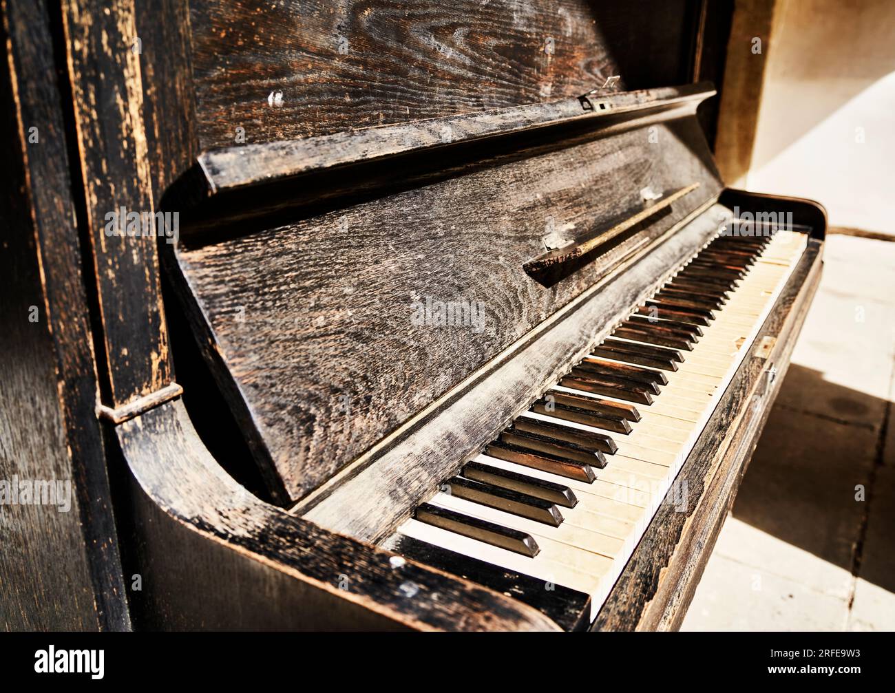 Vecchio pianoforte con legno intemprato, vernice sbucciata e chiavi usurate Foto Stock