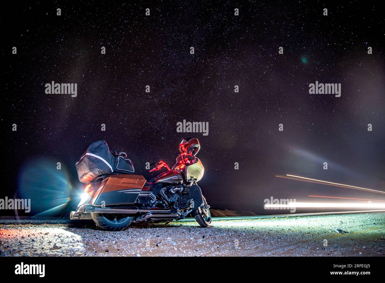 un motociclista si perde nel deserto di notte Foto Stock