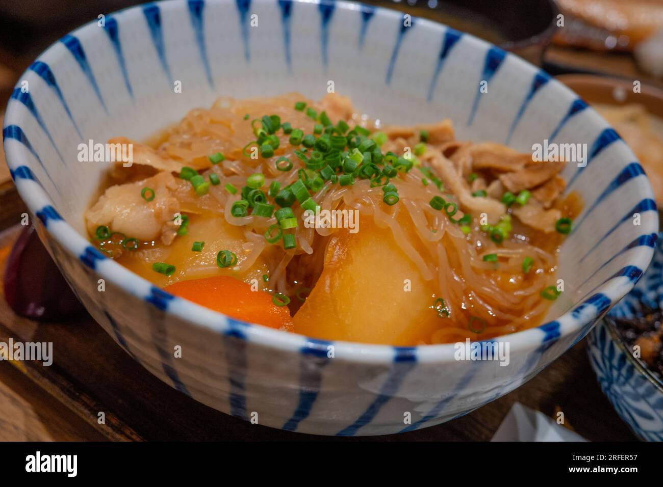 L'Izakaya è un tipo di bar giapponese informale che serve bevande alcoliche e spuntini. Ravanello bianco e rosso marinato con spaghetti di riso in salsa di soia dolce. Foto Stock