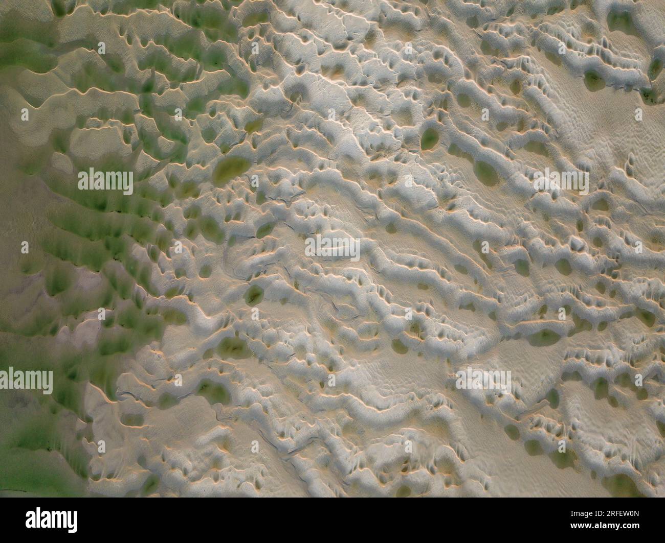 Francia, somme, Baie de somme, le Hourdel, soleil couchant sur le Hourdel à l'extrémité du cordon de galets alors que la marée basse dévoile les méandres des chenaux et les reliefs des bancs de Sable (vue aérienne) Foto Stock