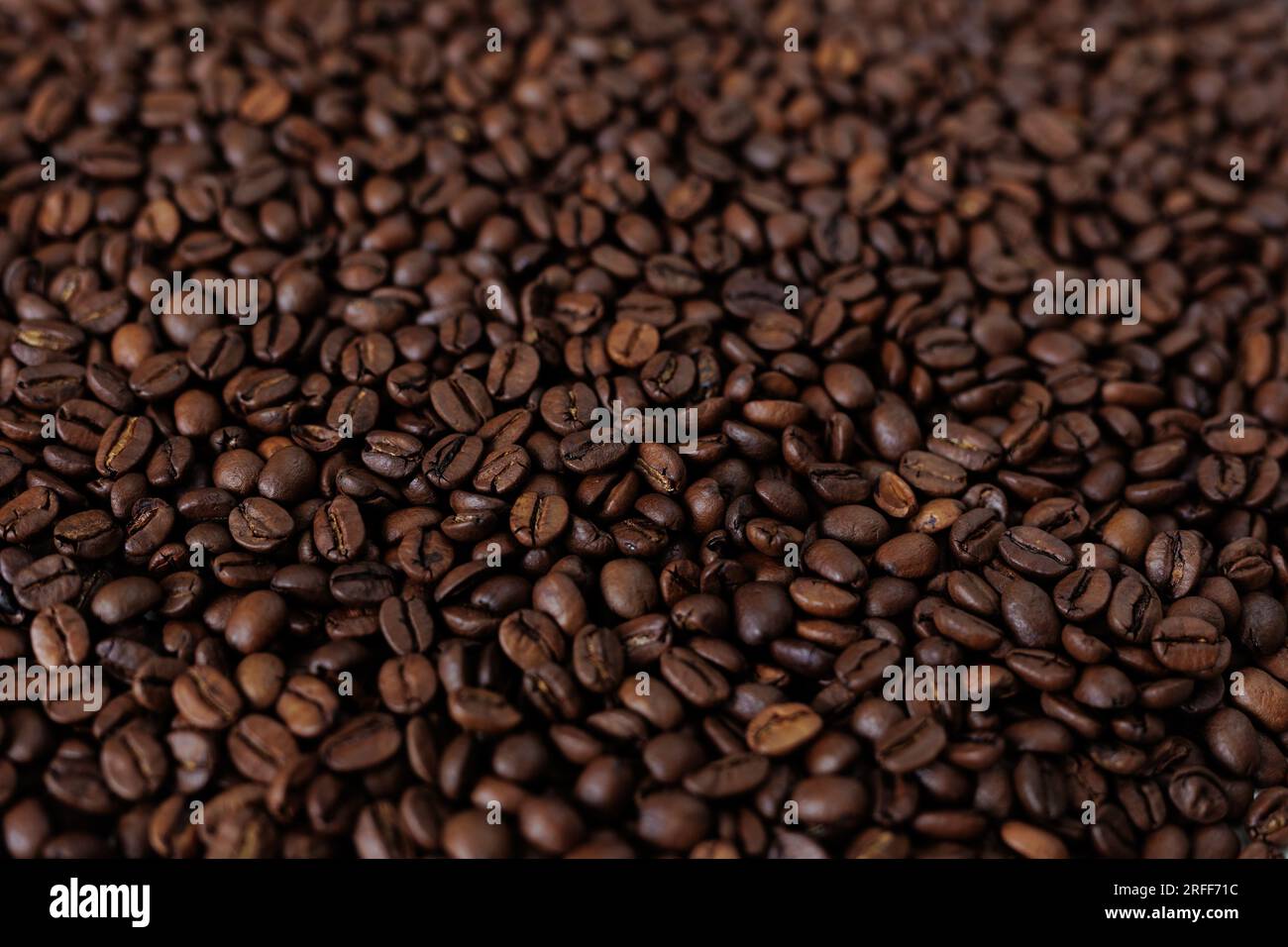 Vista dall'alto dello sfondo che rappresenta metà dei chicchi di caffè marrone scuro con profumo piacevole Foto Stock