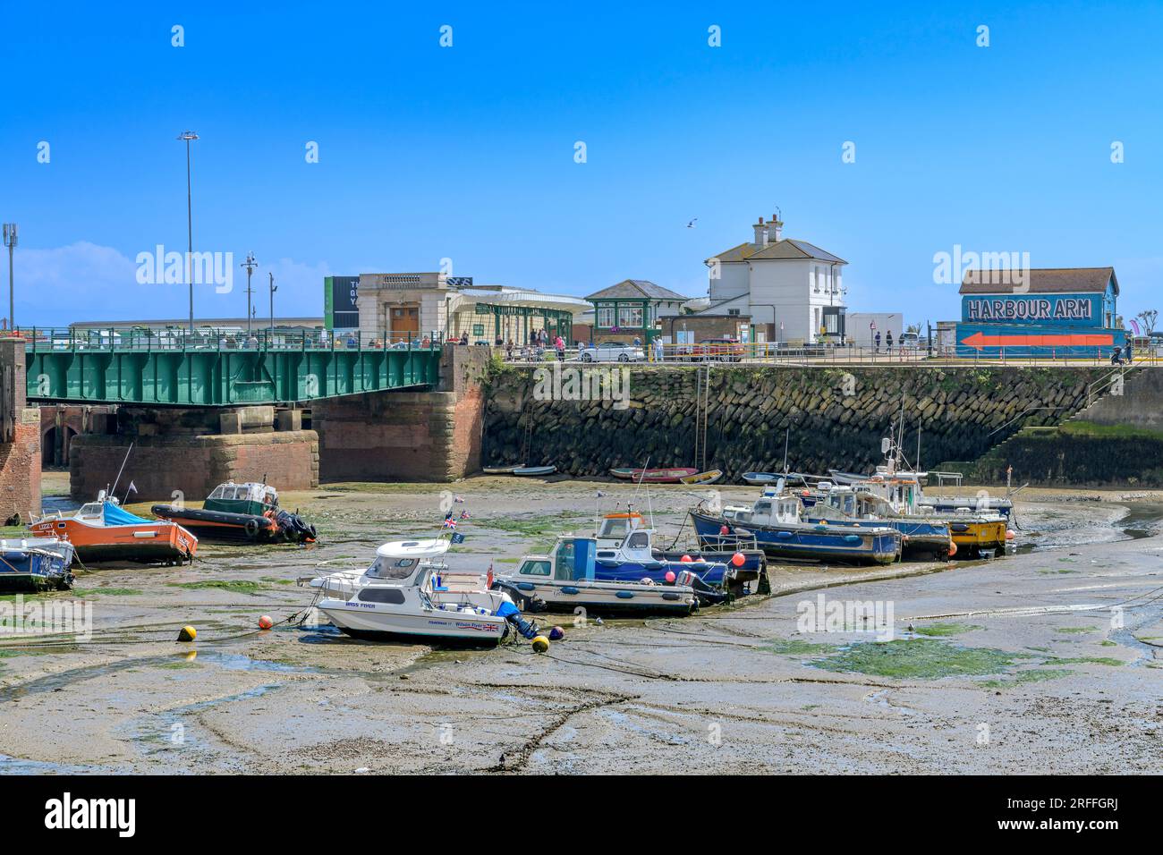 Il porto di Folkestone, con la bassa marea, rende le barche incagliate. Circondato da furgoni di pesce, bancarelle e ristoranti, questo lo rende una destinazione popolare. Foto Stock