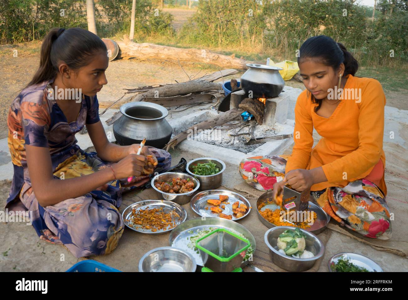 Ragazze del Rajasthan che preparano la cena di famiglia all'aperto Foto Stock