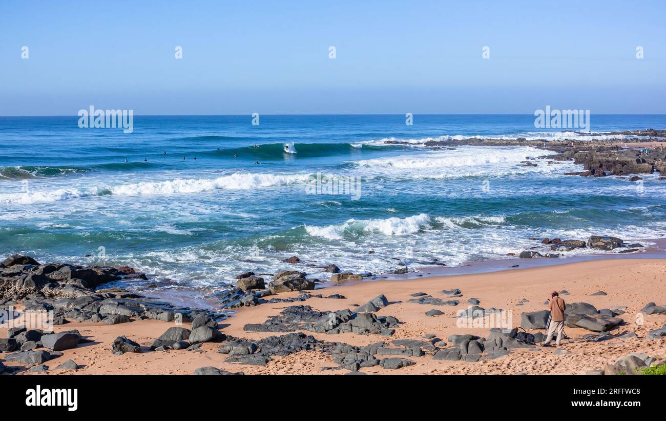 I surfisti raggruppavano le calette rocciose della spiaggia, le piccole onde blu dell'oceano, uno stile di vita all'aperto panoramico. Foto Stock