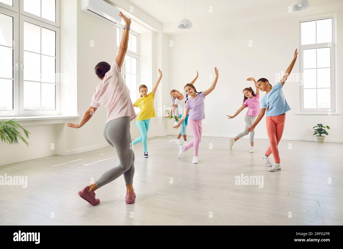 Gruppo di bambini che imparano la danza si muove con insegnante di coreografia alla scuola di danza Foto Stock