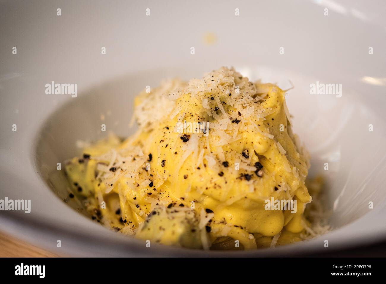 Uovo, formaggio e pasta, nota come Pasta Carbonara, in una ciotola in un ristorante romano. Foto Stock