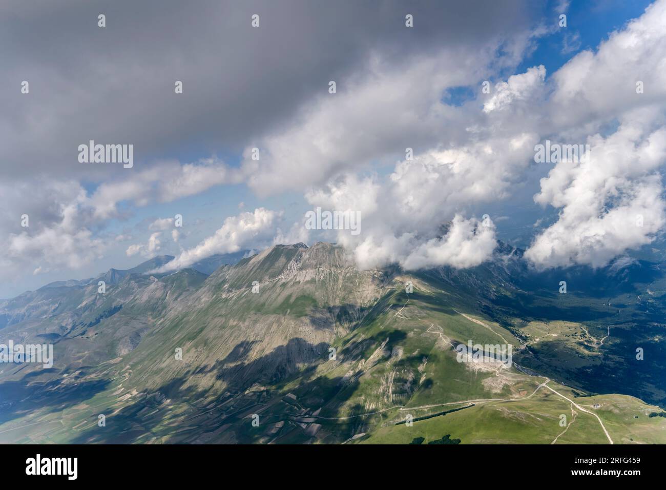 Paesaggio aereo, da un aliante, con pendii aridi della vetta vettore circondati da nuvole di brezza marina, scattate da sud-ovest in un'estate luminosa Foto Stock