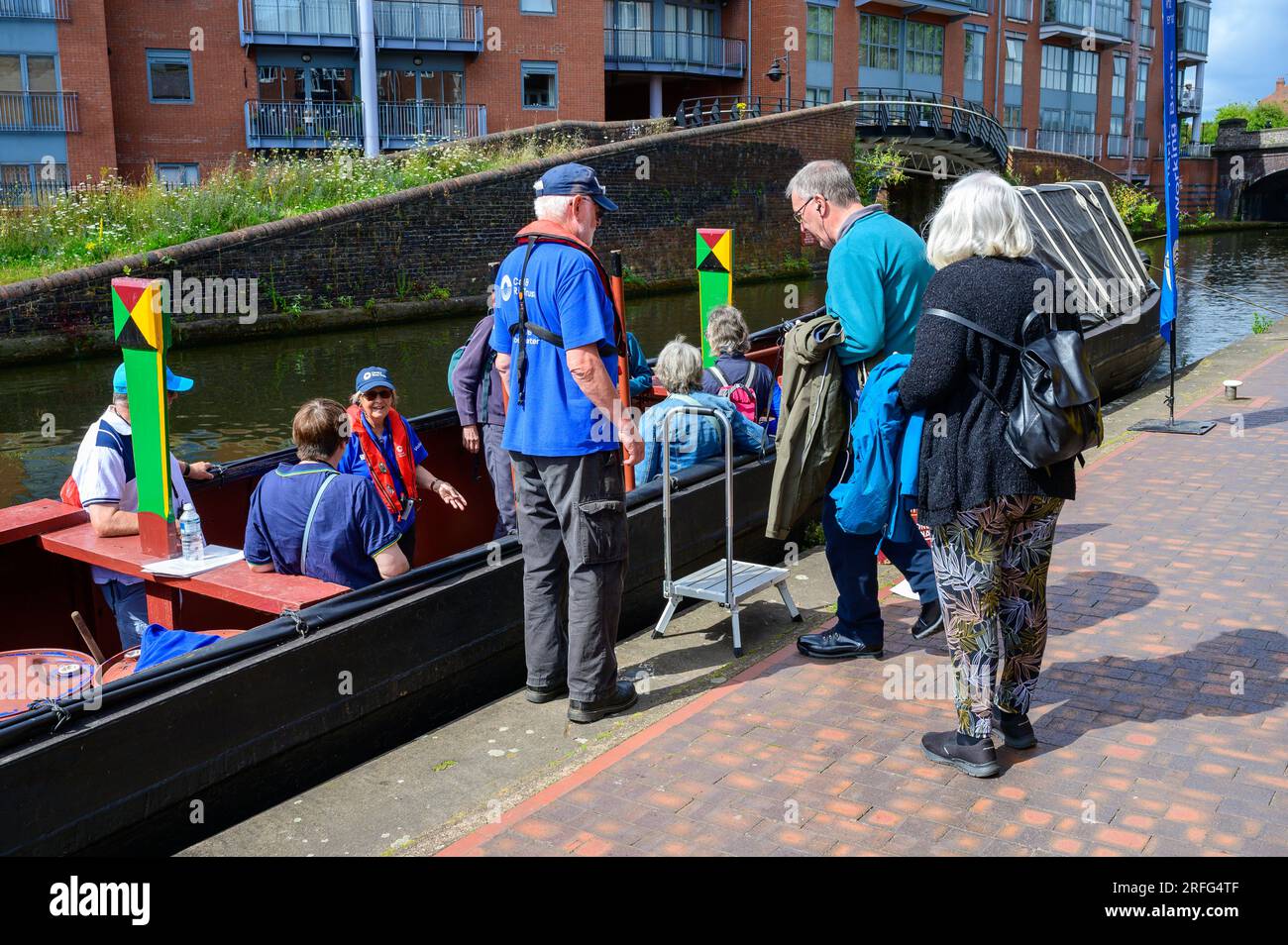 I passeggeri fanno un viaggio a bordo di un tradizionale narrowboat su un canale di Birmingham Foto Stock