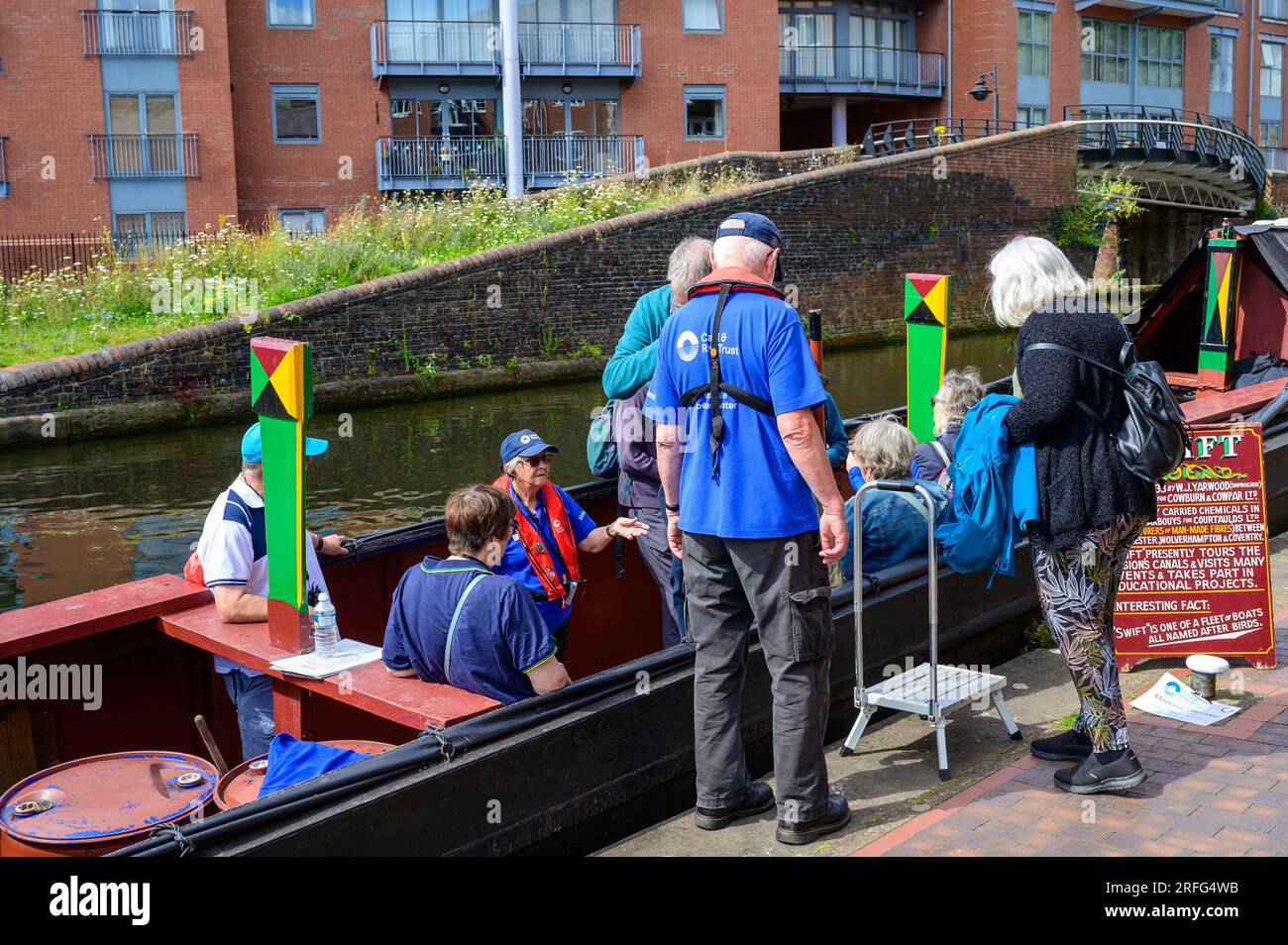 I passeggeri fanno un viaggio a bordo di un tradizionale narrowboat su un canale di Birmingham Foto Stock