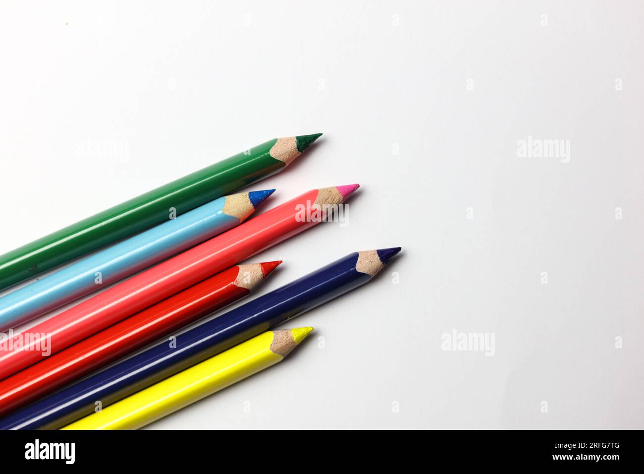 un mucchio di matite coloranti arcobaleno su sfondo bianco Foto Stock