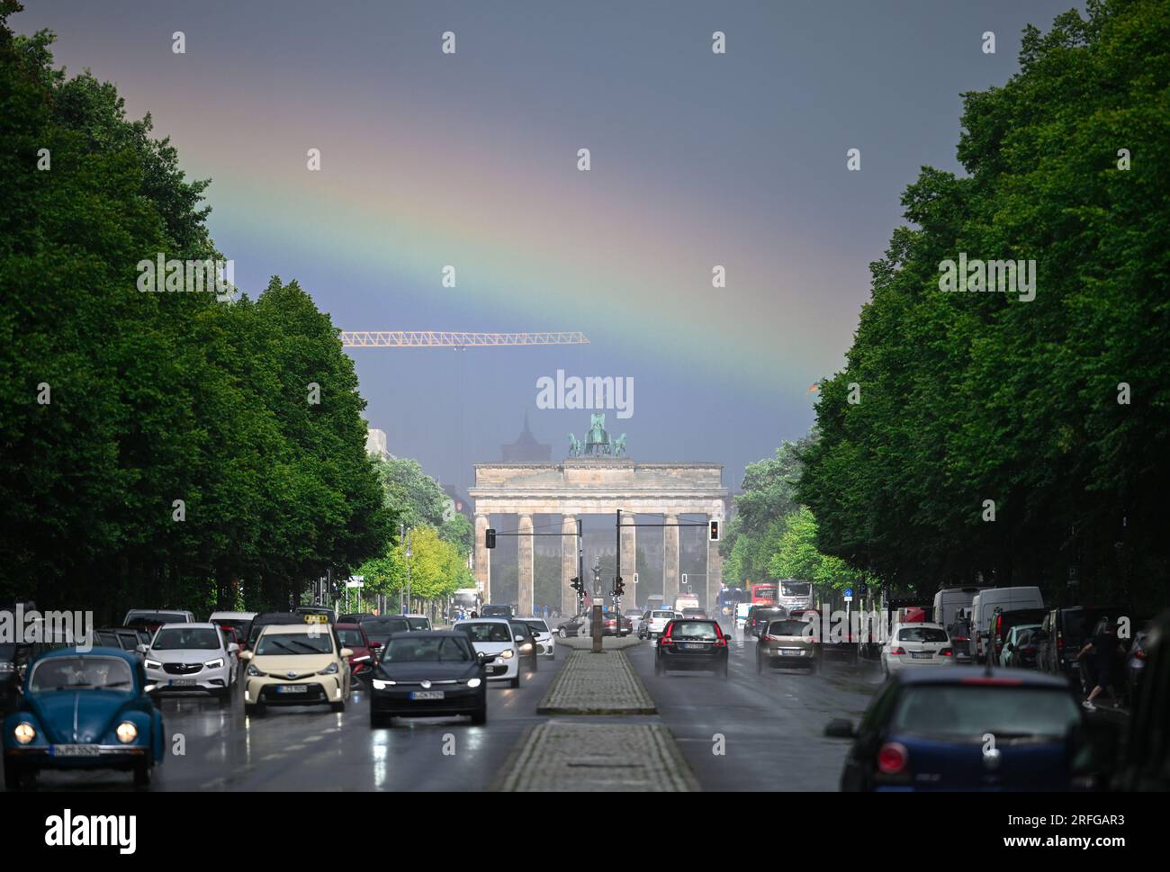 Berlino, Germania. 3 agosto 2023. Durante la pioggia, un arcobaleno può essere visto per un breve momento sopra la porta di Brandeburgo e il Straße des 17. Credito: Soeren Stache/dpa/Alamy Live News Foto Stock