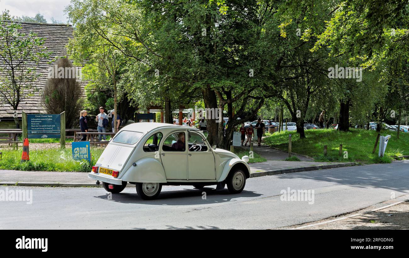 Retro Citroen 2CV su strada panoramica, evocando un viaggio nostalgico e trasporto d'epoca. Foto Stock