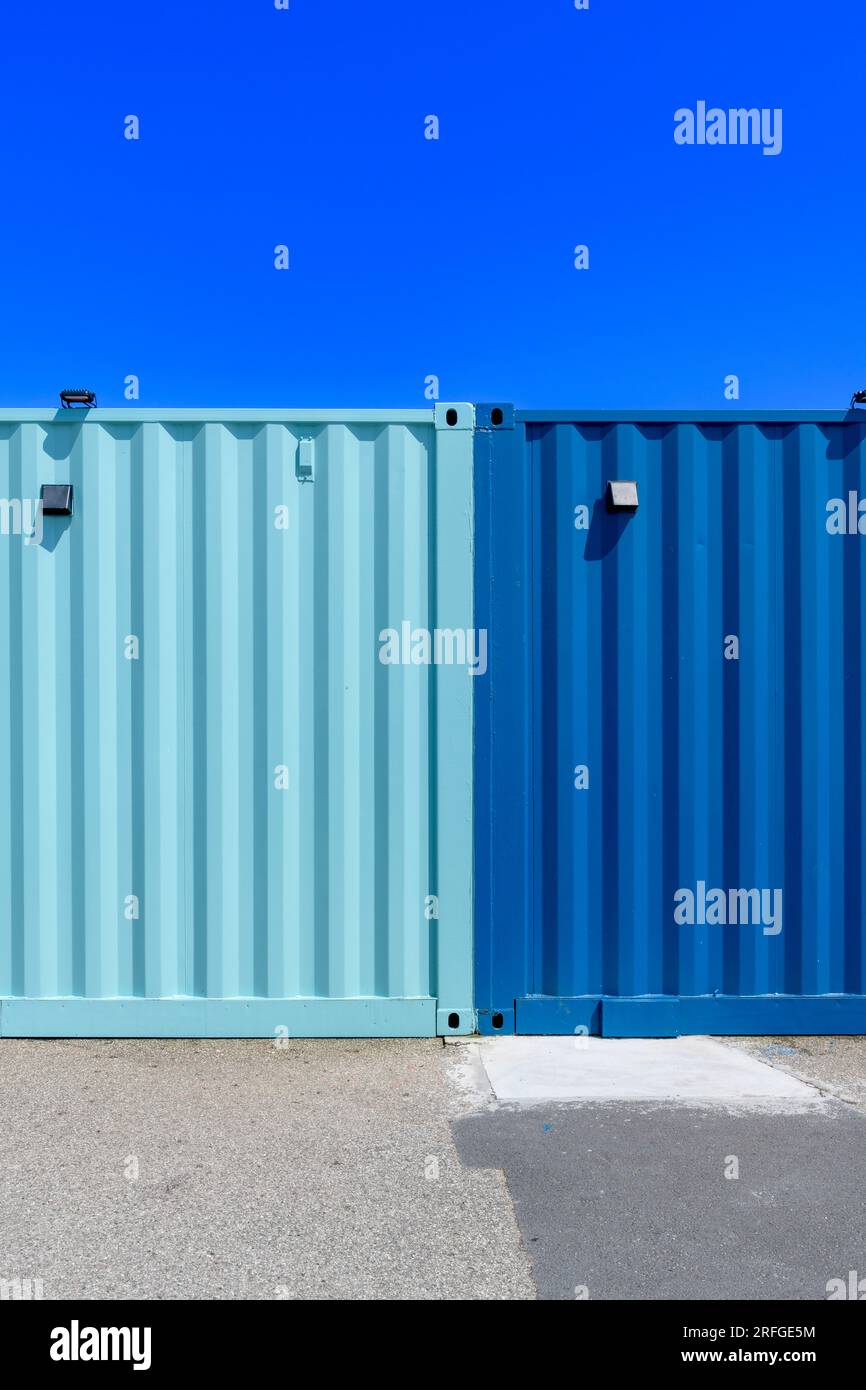 Coloratissimi container utilizzati come bar e caffetterie sul Harbour Arm di Folkestone, Kent. Verniciato in una combinazione di colori blu scuro e ottanio. Foto Stock