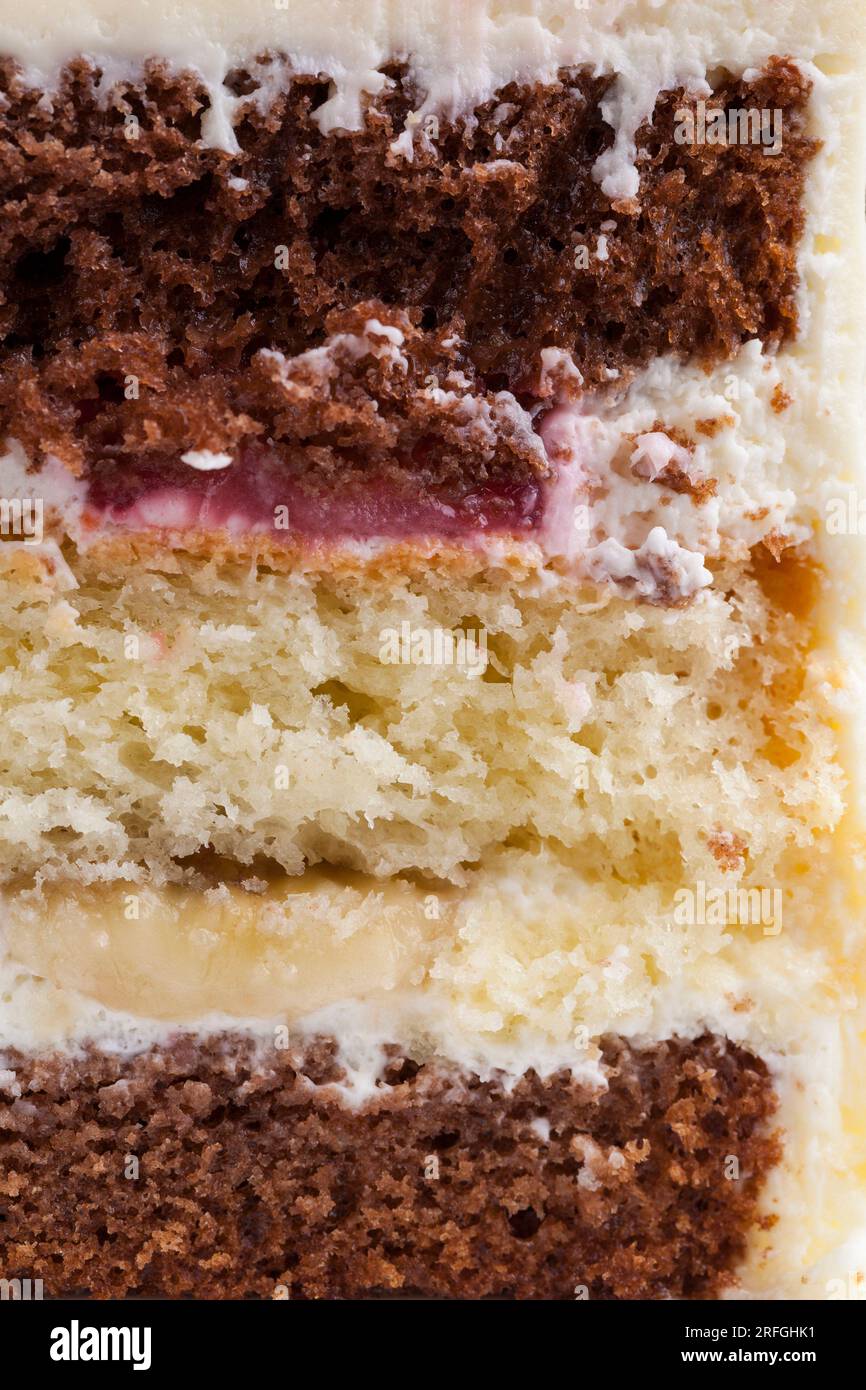 deliziosa torta di dolci misti e farciture di fragole e banane, un pezzo di torta di vaniglia e torte al cioccolato farcite con fragole a. Foto Stock