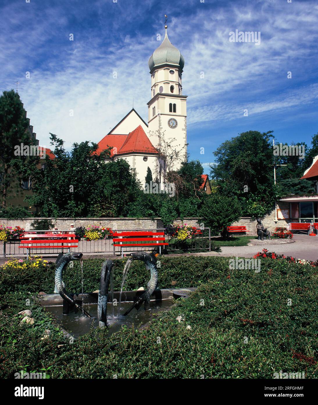 Germania. Regione del lago di Costanza. Wasserburg am Bodensee. Chiesa di San Giorgio, giardini e fontana. Foto Stock