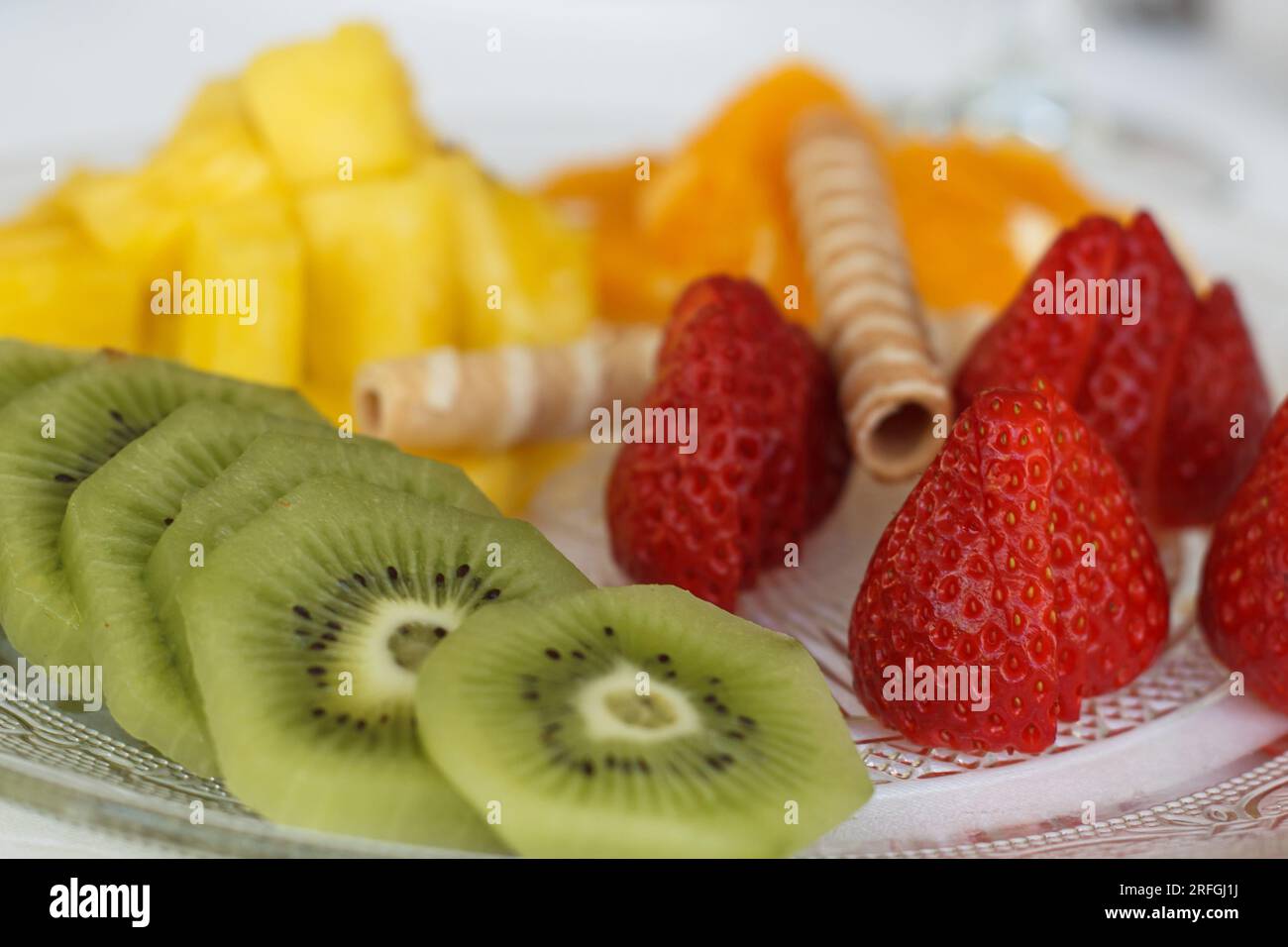 Piatto di frutta preparato con kiwi, arancia, fragole e ananas Foto Stock