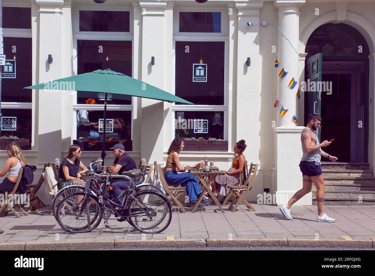 Inghilterra, East Sussex, Brighton, Hove, Western Road, La gente sedeva fuori dal T@Hove Cafe. Foto Stock