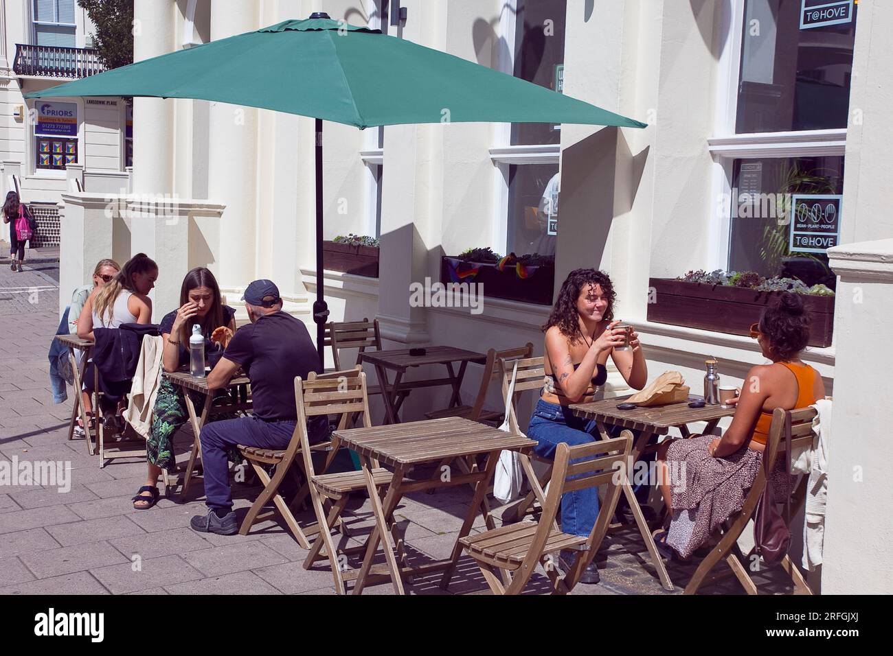 Inghilterra, East Sussex, Brighton, Hove, Western Road, La gente sedeva fuori dal T@Hove Cafe. Foto Stock