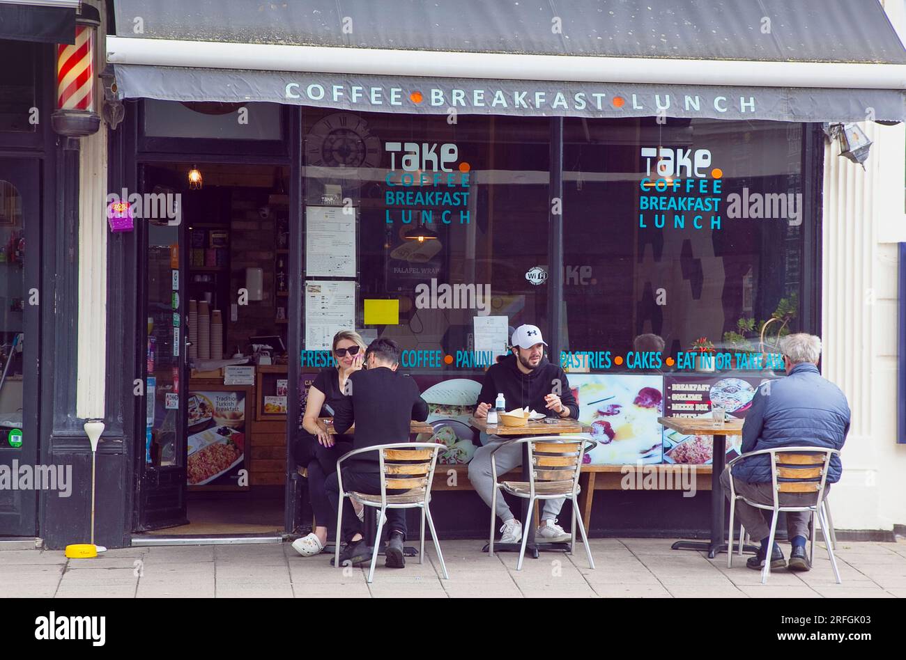 Inghilterra, East Sussex, Brighton, Hove, Western Road, La gente Sat fuori porta porta il Turkish Cafe per mangiare e bere. Foto Stock