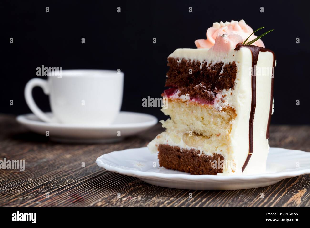 deliziosa torta di dolci misti e farciture di fragole e banane, un pezzo di torta di vaniglia e torte al cioccolato farcite con fragole a. Foto Stock