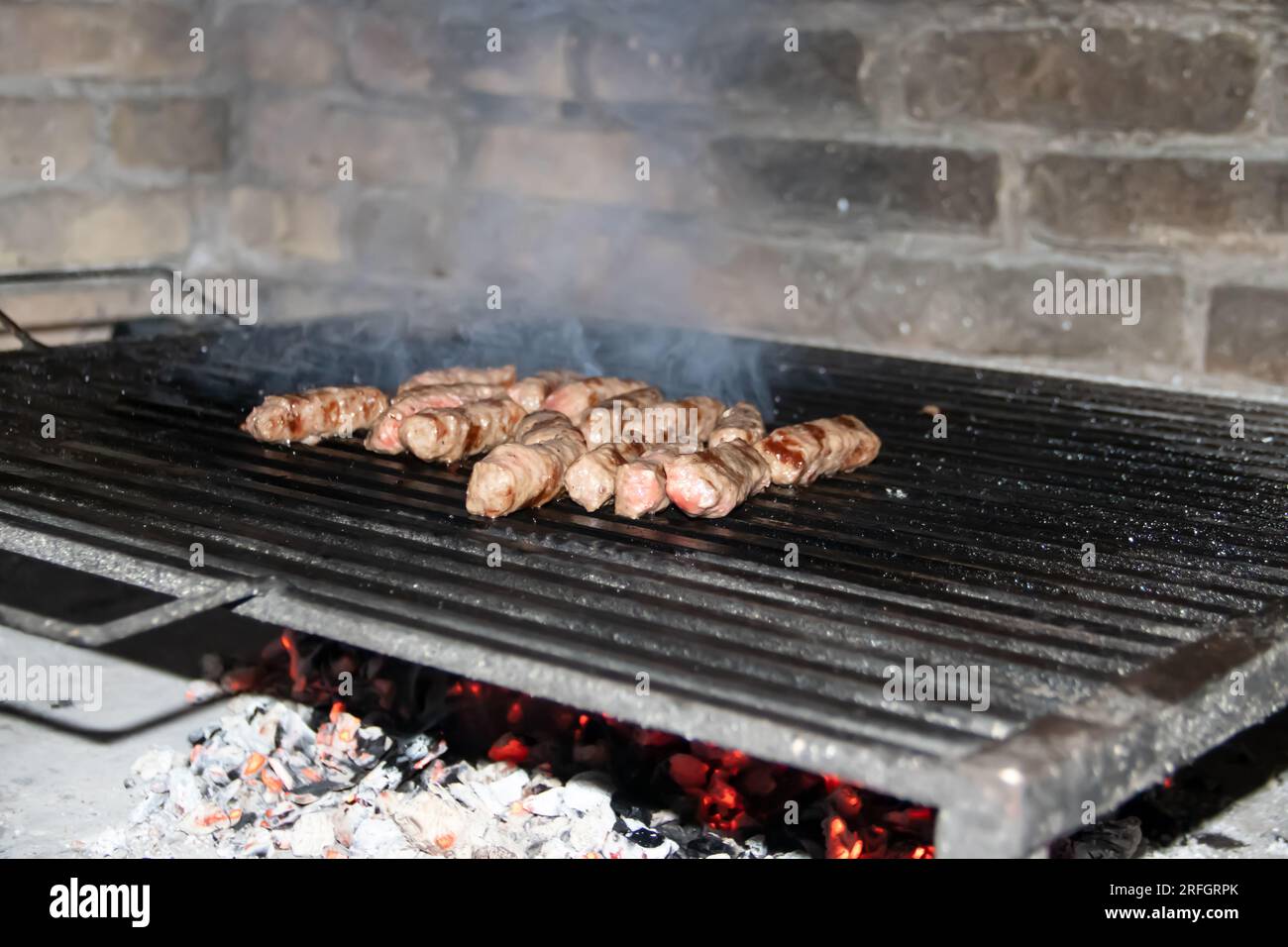 Barbecue Grill sul retro della campagna, preparazione, grigliatura cevapcici (piatto tradizionale balcanico popolare in Serbia, Bosnia e regione), alla griglia Foto Stock