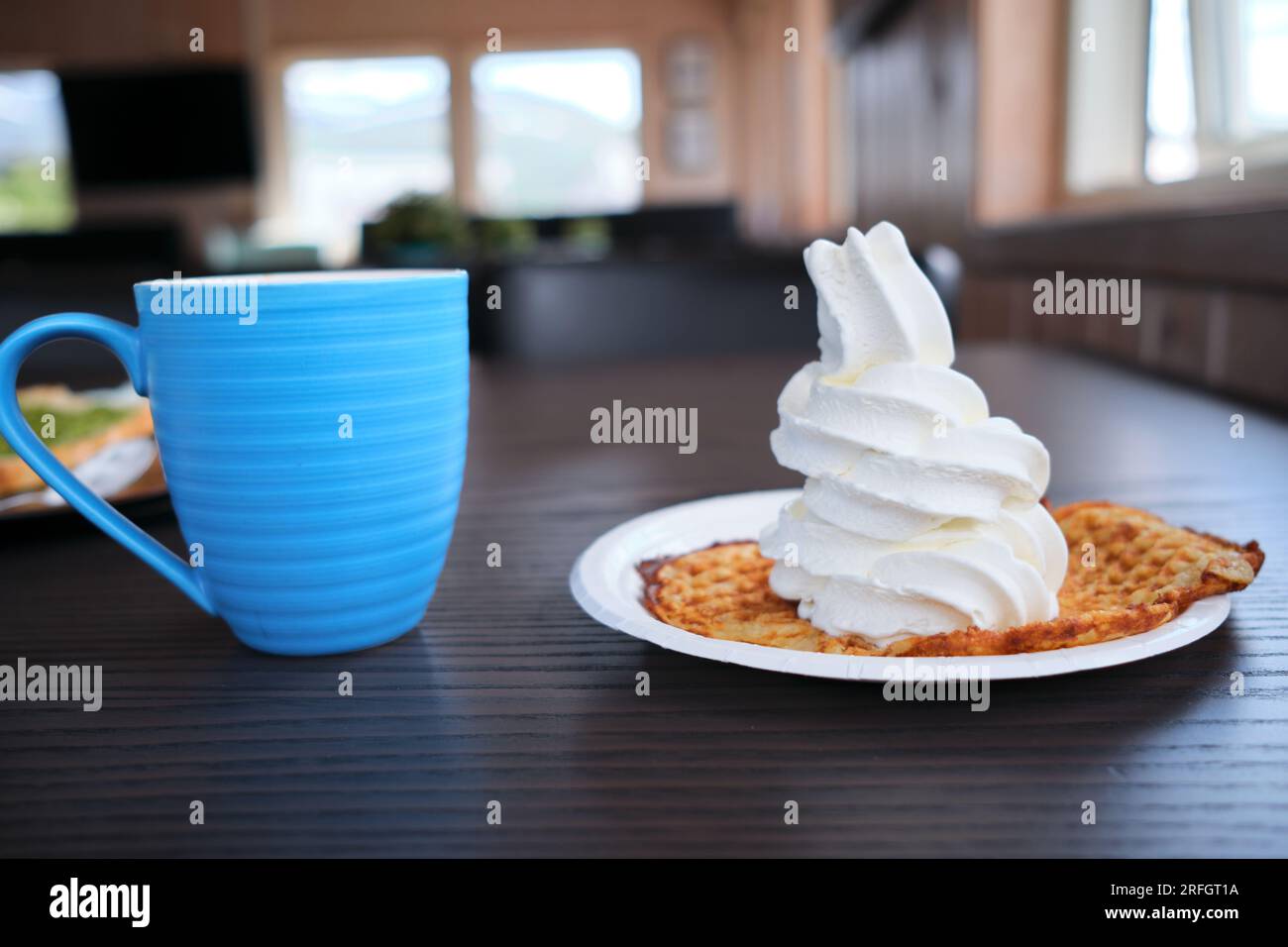 Gelato soffice su waffle tradizionali norvegesi e tazza blu Foto Stock