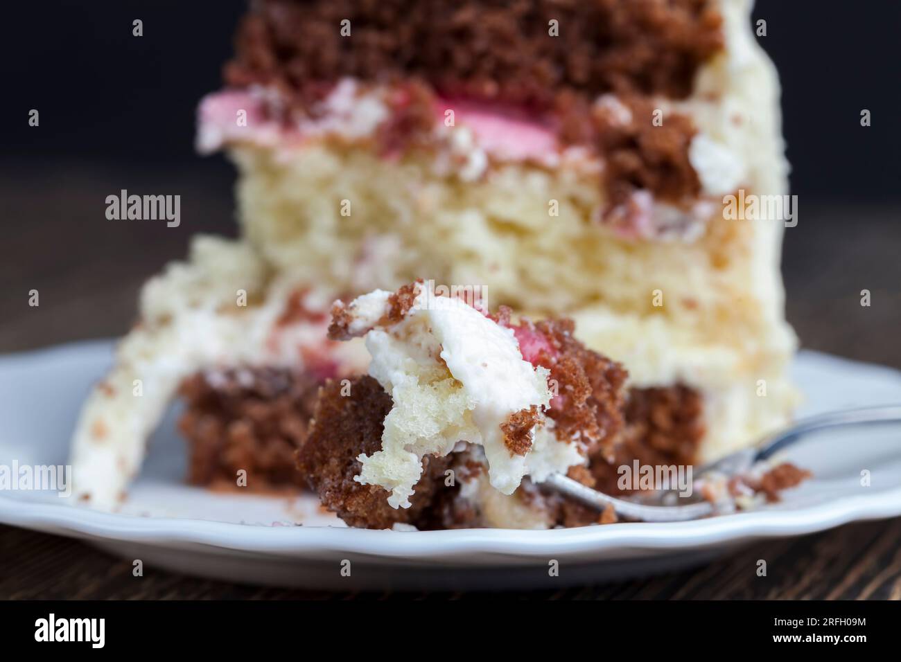 deliziosa torta di dolci misti e farciture di fragole e banane, un pezzo di torta di vaniglia e torte al cioccolato farcite con fragole a. Foto Stock