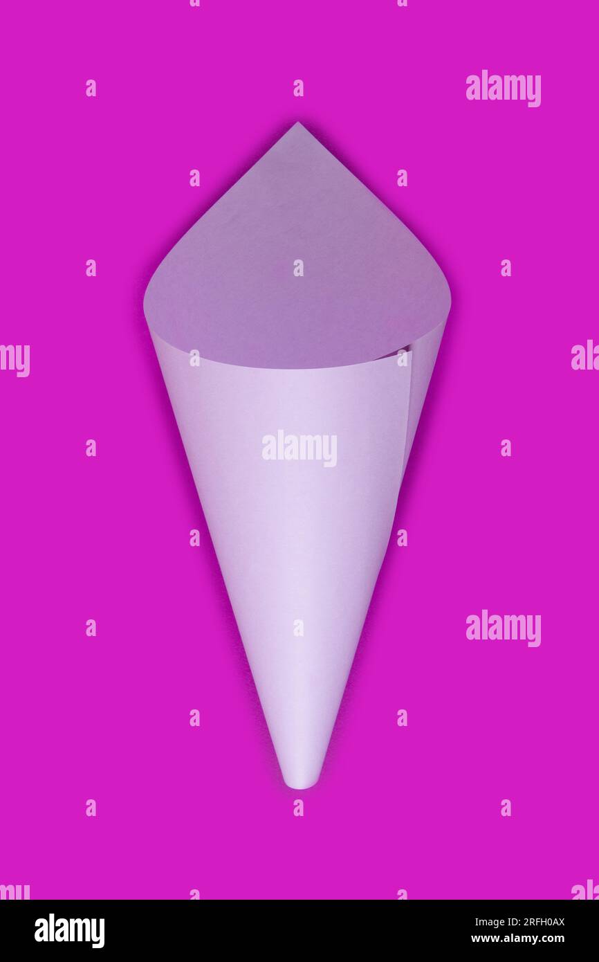 Il cono di carta viola chiaro vuoto si trova su sfondo fuksia. Colori vivaci Mockup di confezione per fiori Foto Stock