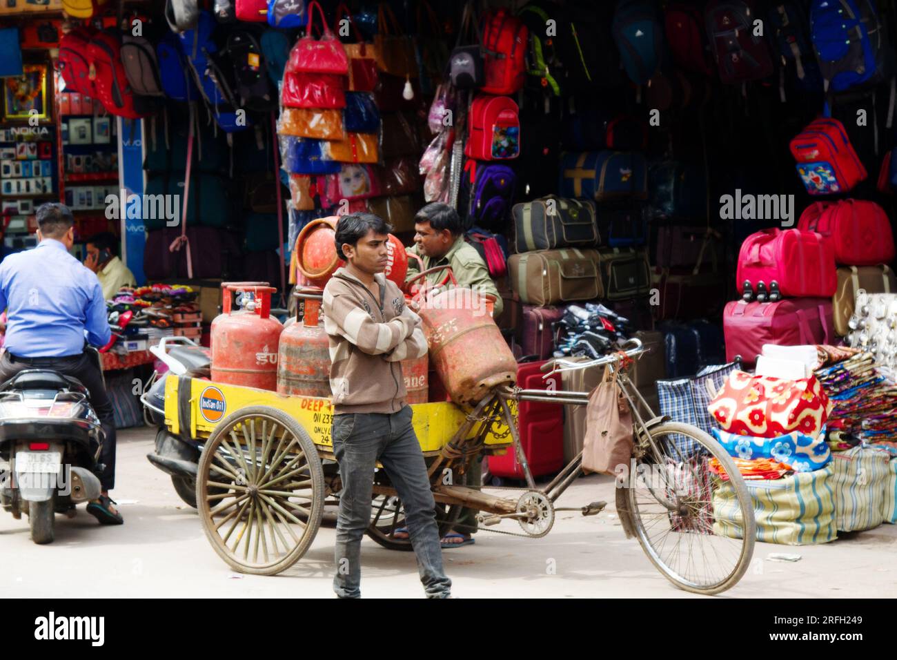 India, nuova Delhi - 1 marzo 2018: Venditore di gas con negozi di carri di venditori di borse e zaini Foto Stock